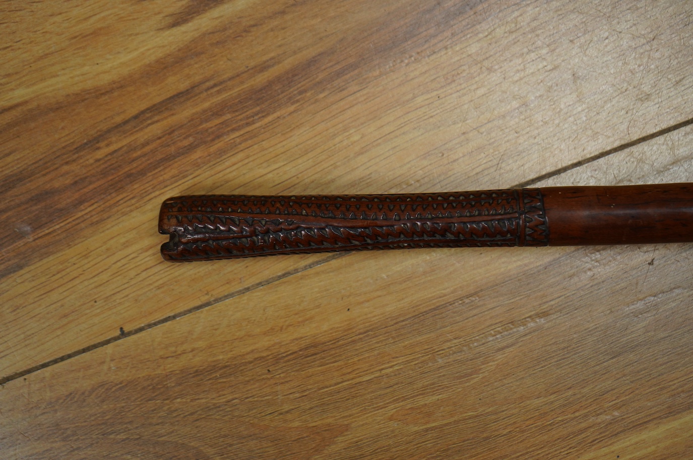 A 19th century Fiji hardwood throwing club, Ula, 39cm long, bulbous head with incisions, the grip carved with zigzag decoration. Condition - good, formerly with bone inlay to the head